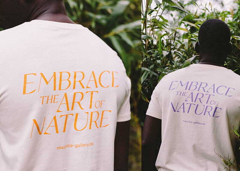 Copanero font in use by Mauritia Gallery from Berlin, Germany. A man in the jungle wearing a T-shirt that says Embrace The Art Of Nature.